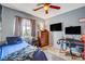 Comfortable bedroom with large window, ceiling fan, and a sleek workstation area at 9992 Oyster Pearl St, Las Vegas, NV 89183