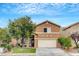 Two-story home with a well-manicured lawn, mature trees, and an attached two-car garage at 9992 Oyster Pearl St, Las Vegas, NV 89183
