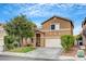Charming front exterior featuring a two-car garage, green lawn, and mature landscaping at 9992 Oyster Pearl St, Las Vegas, NV 89183