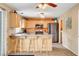 Well-lit kitchen with wooden cabinets, stainless steel appliances, and breakfast bar with stool seating at 9992 Oyster Pearl St, Las Vegas, NV 89183
