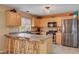 Spacious kitchen with stainless appliances, a breakfast bar with stool seating, and light wood cabinetry at 9992 Oyster Pearl St, Las Vegas, NV 89183