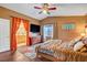 Warm main bedroom with wood floors, TV on dresser and doorway view to the en suite bathroom at 9992 Oyster Pearl St, Las Vegas, NV 89183