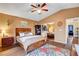 Cozy main bedroom featuring a ceiling fan, wood floors, dresser and a mirrored closet at 9992 Oyster Pearl St, Las Vegas, NV 89183