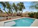 Sparkling pool surrounded by lush landscaping, mature trees, and a relaxing hammock at 9992 Oyster Pearl St, Las Vegas, NV 89183