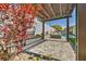 Beautiful backyard patio with pergola, stone pavers, outdoor fireplace, and partial view of the pool at 10062 Mountain Foothills Ave, Las Vegas, NV 89149