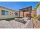 Private backyard patio featuring a pergola, stone pavers, and a cozy outdoor fireplace at 10062 Mountain Foothills Ave, Las Vegas, NV 89149