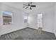 A bright bedroom features a ceiling fan, carpeted floors, and two windows offering plenty of natural light at 10062 Mountain Foothills Ave, Las Vegas, NV 89149