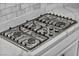 Gas cooktop with stainless steel burners set in white marble countertops and backsplash at 10062 Mountain Foothills Ave, Las Vegas, NV 89149