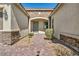 Welcoming front entrance featuring a brick walkway, manicured landscaping, and a charming front door at 10062 Mountain Foothills Ave, Las Vegas, NV 89149