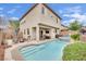 Inviting backyard with a sparkling pool, jacuzzi, covered patio, and lush landscaping at 10368 Pima Crossing Ave, Las Vegas, NV 89166