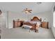 Spacious main bedroom featuring carpet floors, a ceiling fan, and matching wooden furniture at 10368 Pima Crossing Ave, Las Vegas, NV 89166