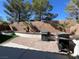 Outdoor kitchen area with brick pavers and a built-in barbecue grill in a well landscaped yard at 10783 Vestone St, Las Vegas, NV 89141
