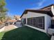 A landscaped yard with synthetic lawn, patio, table, and BBQ grill is perfect for outdoor enjoyment at 10783 Vestone St, Las Vegas, NV 89141