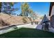 Well-manicured backyard with synthetic lawn and patio, complete with outdoor dining and barbecue area at 10783 Vestone St, Las Vegas, NV 89141