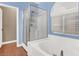 Bathroom with glass shower enclosure, soaking tub, and bright natural lighting at 10783 Vestone St, Las Vegas, NV 89141