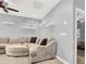 Comfortable living room featuring a plush sectional sofa, ceiling fan, and modern floating shelves at 10783 Vestone St, Las Vegas, NV 89141