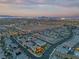 Wide aerial view of a sprawling suburban neighborhood with well-lit homes and city lights in the distance at 10988 Wonder Hills St, Las Vegas, NV 89141