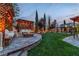 Backyard with a fire pit, built-in seating, mature trees, and pavers at 10988 Wonder Hills St, Las Vegas, NV 89141