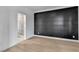 Modern bedroom with sleek hardwood floors and a stylish accent wall, leading to a beautifully updated bathroom at 10988 Wonder Hills St, Las Vegas, NV 89141
