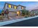 Well-maintained two-story home with a two-car garage and illuminated front yard landscaping at 10988 Wonder Hills St, Las Vegas, NV 89141