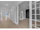 A bright hallway featuring beautiful hardwood floors and decorative trim, leading to various rooms in the house at 10988 Wonder Hills St, Las Vegas, NV 89141