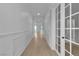 Long hallway featuring elegant white wainscoting and trim and bright, welcoming natural light from the entryway at 10988 Wonder Hills St, Las Vegas, NV 89141