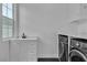 Functional laundry room with washer, dryer, sink, and storage cabinets at 10988 Wonder Hills St, Las Vegas, NV 89141
