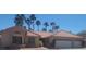 Single-story home showcasing a terra cotta roof, three car garage, and desert landscaping with palm trees at 1163 Spanish Armada Rd, Las Vegas, NV 89123