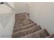 Carpeted staircase featuring neutral walls and a white handrail at 1187 Kiamichi Ct, Henderson, NV 89002