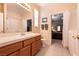 Bright bathroom with a large mirror, wood cabinets, and a view into an adjacent bedroom at 1313 Gallery Oaks Dr, Las Vegas, NV 89123