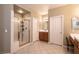 Bright bathroom featuring tiled floors, a glass shower, and oak vanity with framed mirror at 1313 Gallery Oaks Dr, Las Vegas, NV 89123