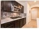 Well-equipped kitchen with stainless appliances, dark cabinetry, mosaic backsplash, and light countertops at 1313 Gallery Oaks Dr, Las Vegas, NV 89123
