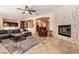 Spacious living room featuring a stone fireplace, tile flooring, and modern ceiling fan at 1313 Gallery Oaks Dr, Las Vegas, NV 89123