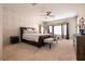 Large main bedroom with textured wall accent, ceiling fan and sitting area by the window at 1313 Gallery Oaks Dr, Las Vegas, NV 89123