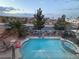 Aerial view showcasing the backyard pool, spa, and surrounding neighborhood at twilight at 1486 Neyland Dr, Henderson, NV 89012