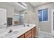 Bright bathroom featuring double sinks, a large mirror, and a shower with glass doors at 1486 Neyland Dr, Henderson, NV 89012