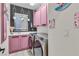 Charming laundry room with pink cabinets and modern appliances at 1486 Neyland Dr, Henderson, NV 89012