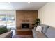 Charming brick fireplace in a living room with sliding glass doors leading to an outdoor patio and lush greenery at 1513 Kirkland Ave, Las Vegas, NV 89102