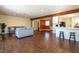 Open-concept living area featuring hardwood floors, a grey sofa, and a kitchen with a breakfast bar and barstool seating at 1513 Kirkland Ave, Las Vegas, NV 89102