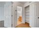 Bathroom with wood floors, a wooden vanity, white walls, and an adjacent shelved closet at 1552 Wild Willey Way, Henderson, NV 89002