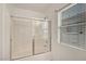 Bathroom featuring shower over tub, sliding glass door and window at 1552 Wild Willey Way, Henderson, NV 89002