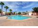 Enjoy the community pool with palm trees, lounge chairs, and a pool house on a sunny day at 1552 Wild Willey Way, Henderson, NV 89002