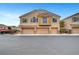 Inviting townhouse featuring three-car garage, neutral stucco exterior, and low maintenance landscaping at 1552 Wild Willey Way, Henderson, NV 89002