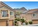 Exterior showcasing a community of two-story townhomes, featuring well-kept landscaping, mountain views and attached garages at 1552 Wild Willey Way, Henderson, NV 89002