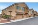 Attractive townhouse showcasing a three-car garage, neutral stucco, and well-maintained landscaping at 1552 Wild Willey Way, Henderson, NV 89002