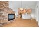 Spacious living area featuring a stone fireplace, hardwood floors, and adjacent kitchen with an open layout at 1552 Wild Willey Way, Henderson, NV 89002