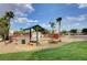 Community picnic area featuring a covered table and benches near a grassy lawn and palm trees at 1552 Wild Willey Way, Henderson, NV 89002