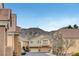 Street view of charming townhomes set against a mountain backdrop, showing a well-maintained neighborhood with community charm at 1552 Wild Willey Way, Henderson, NV 89002