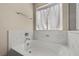 Soaking bathtub with a modern faucet, complemented by elegant marble-like countertops and a bright window at 168 Springhouse St, Las Vegas, NV 89148