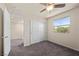 Bright bedroom featuring plush carpeting, a ceiling fan, closet with sliding doors and ample natural light at 168 Springhouse St, Las Vegas, NV 89148
